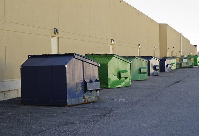 a pile of demolition waste sits beside a dumpster in a parking lot in Clairton